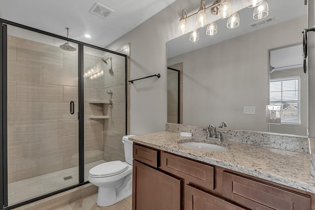 bathroom with vanity, toilet, and a shower with door