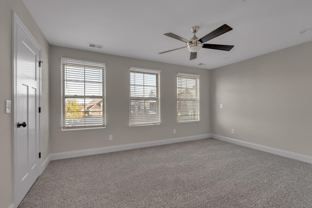 empty room featuring ceiling fan and light colored carpet