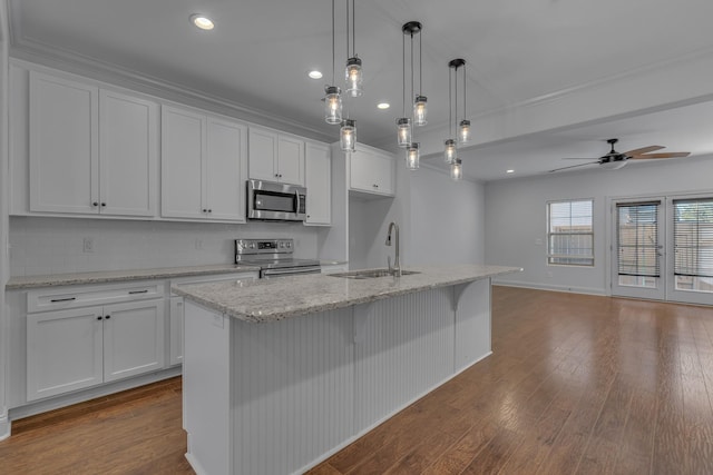 kitchen featuring white cabinetry, a kitchen island with sink, pendant lighting, and stainless steel appliances