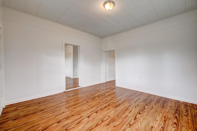 spare room with light wood-type flooring and ornamental molding