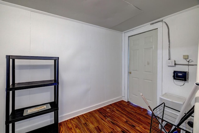 entryway with crown molding and dark wood-type flooring