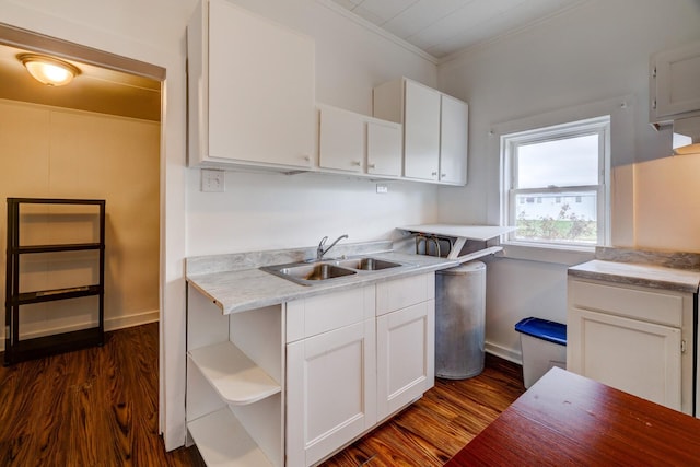 kitchen featuring crown molding, dark hardwood / wood-style flooring, white cabinetry, and sink