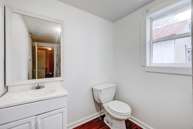 bathroom with vanity, hardwood / wood-style flooring, and toilet