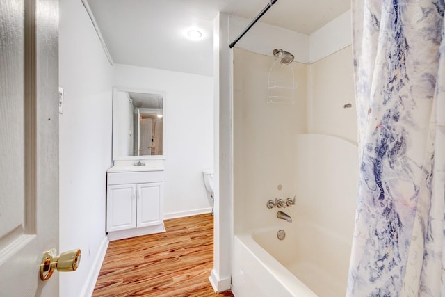 full bathroom featuring hardwood / wood-style floors, vanity, toilet, and shower / tub combo