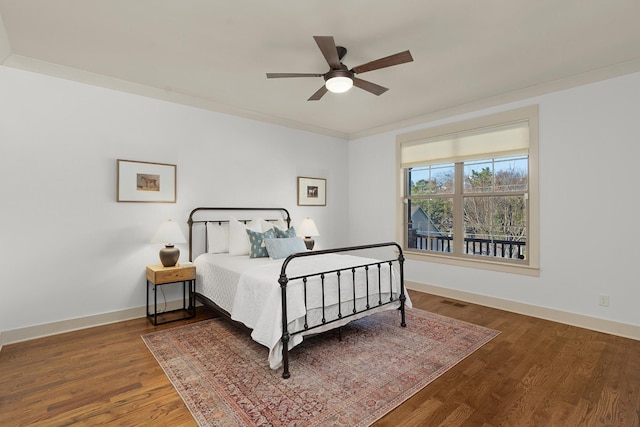 bedroom featuring ceiling fan, ornamental molding, and hardwood / wood-style flooring