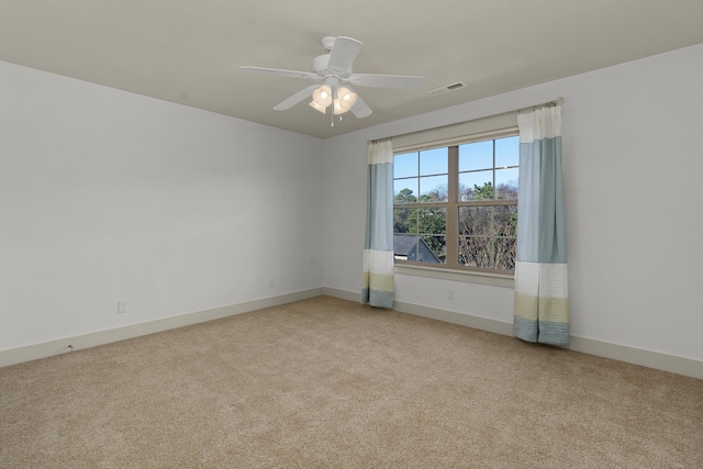 spare room with ceiling fan and light colored carpet