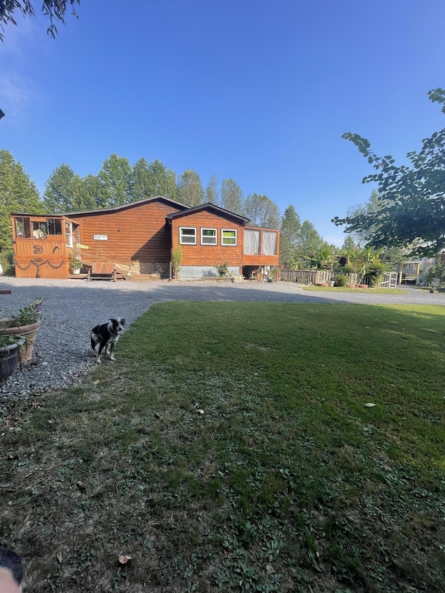 exterior space with a lawn, a wooden deck, and fence