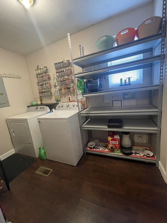 washroom with laundry area, electric panel, baseboards, wood finished floors, and washing machine and dryer