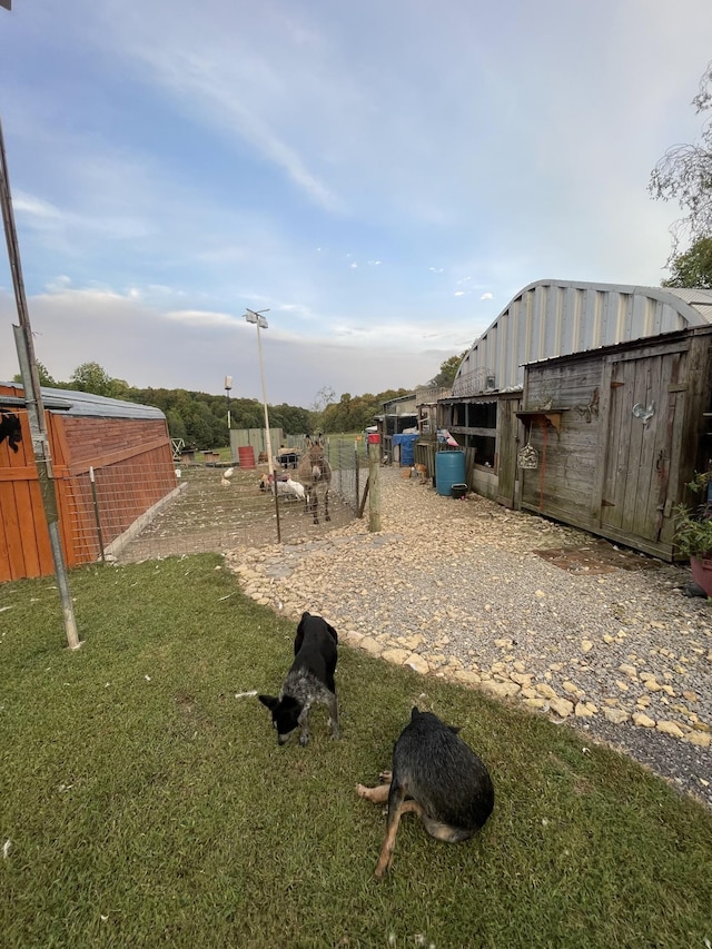 view of yard featuring fence and an outbuilding