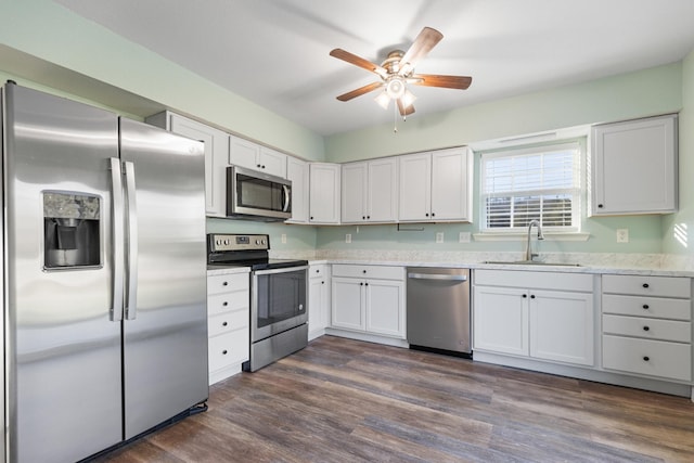 kitchen with stainless steel appliances, ceiling fan, dark wood-type flooring, sink, and white cabinets