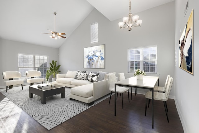 living room with ceiling fan with notable chandelier, hardwood / wood-style flooring, and high vaulted ceiling