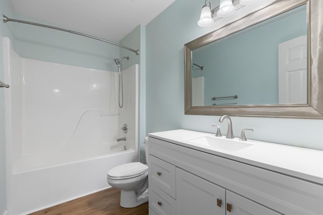 full bathroom featuring hardwood / wood-style flooring, vanity, toilet, and shower / washtub combination