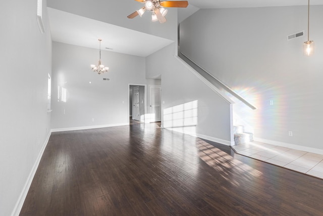 unfurnished living room with high vaulted ceiling, ceiling fan with notable chandelier, and hardwood / wood-style flooring