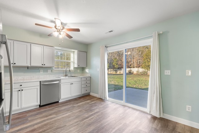 kitchen featuring light hardwood / wood-style flooring, stainless steel dishwasher, plenty of natural light, and sink