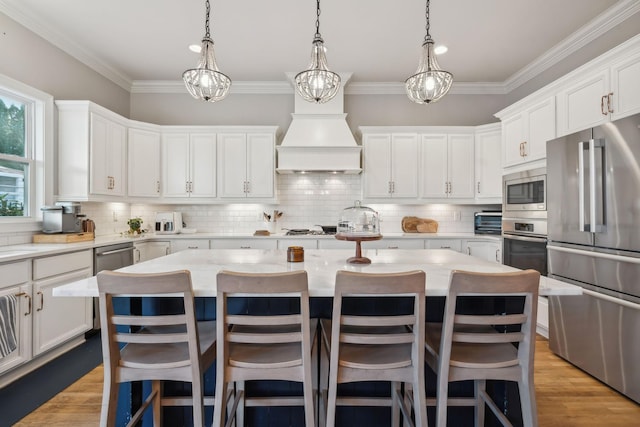 kitchen with white cabinets, a center island, a breakfast bar area, and appliances with stainless steel finishes