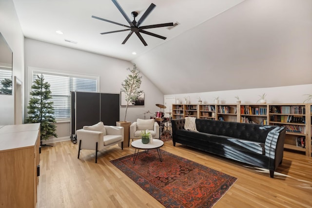 living room with light hardwood / wood-style floors, ceiling fan, and lofted ceiling