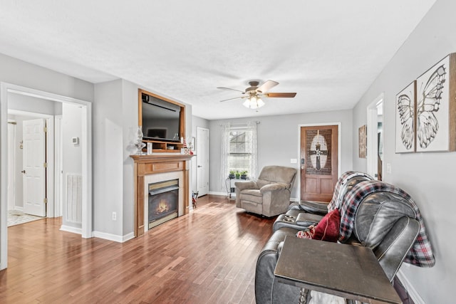 living room with wood-type flooring, a textured ceiling, and ceiling fan