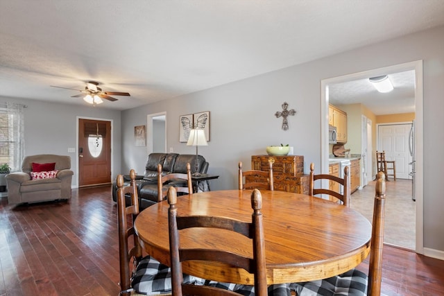 dining space with dark wood-type flooring and ceiling fan