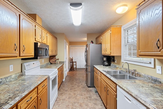 kitchen featuring stainless steel appliances, sink, and a textured ceiling