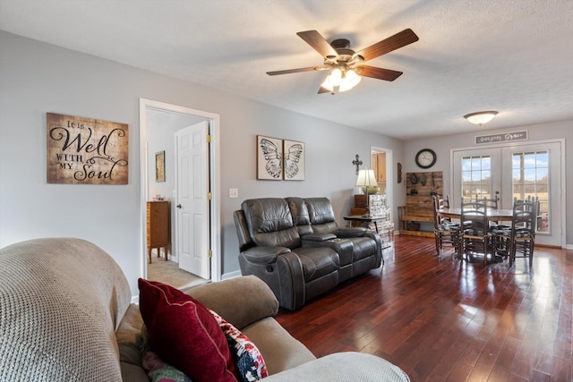 living room with ceiling fan, a textured ceiling, dark hardwood / wood-style flooring, and french doors