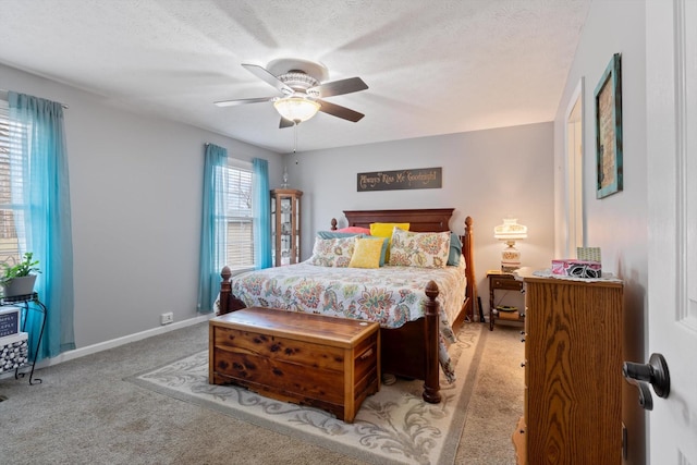 bedroom featuring ceiling fan, light carpet, and a textured ceiling