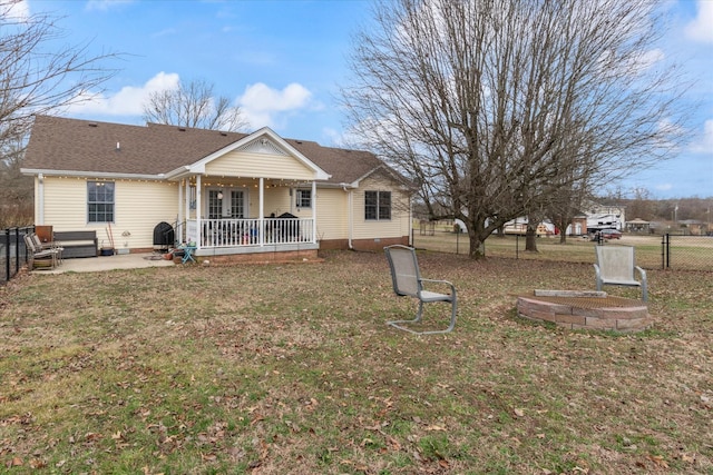 rear view of property featuring a porch, a patio area, and a lawn