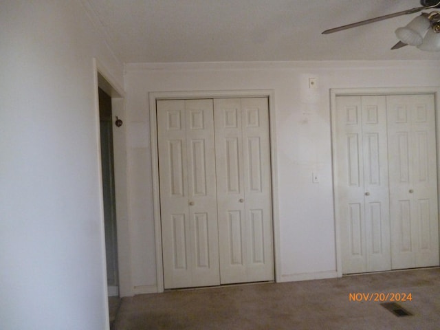 unfurnished bedroom featuring two closets and ceiling fan