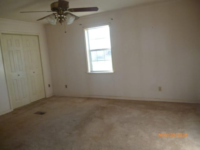 unfurnished bedroom with ceiling fan and a closet