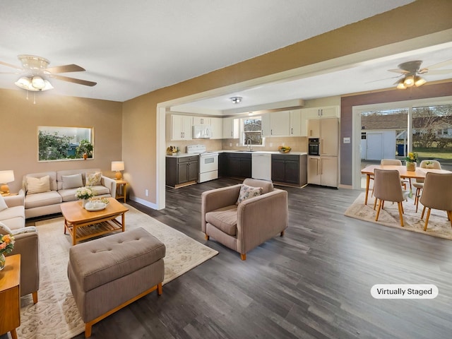 living room with dark hardwood / wood-style floors, ceiling fan, and sink