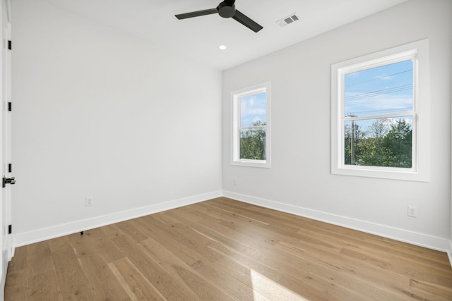 empty room with light hardwood / wood-style floors, plenty of natural light, and ceiling fan