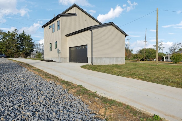 view of side of property featuring a lawn and a garage