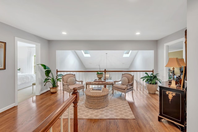 living area with light wood-style floors, recessed lighting, lofted ceiling with skylight, and baseboards