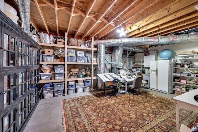 basement featuring white fridge with ice dispenser