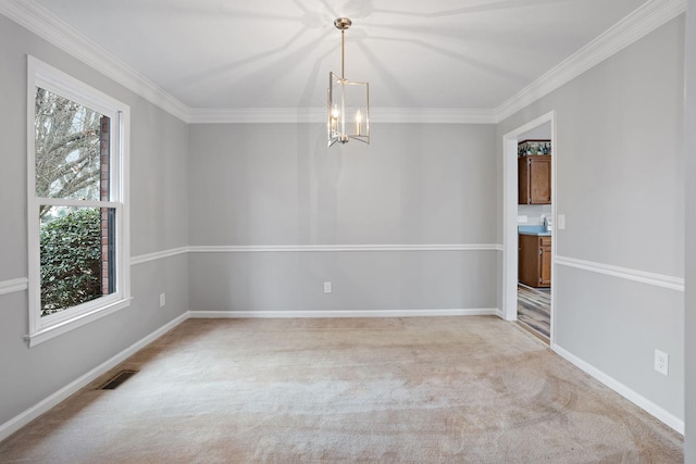 spare room featuring a chandelier, light carpet, and crown molding