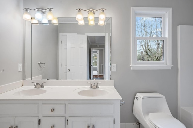 bathroom with vanity, toilet, and a wealth of natural light