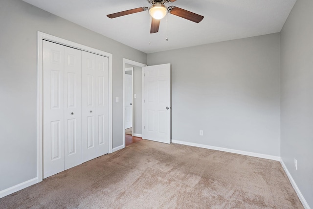 unfurnished bedroom with carpet flooring, ceiling fan, and a closet