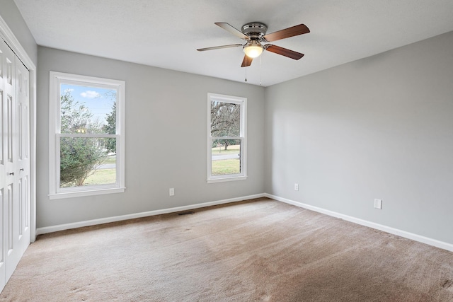 carpeted spare room with ceiling fan