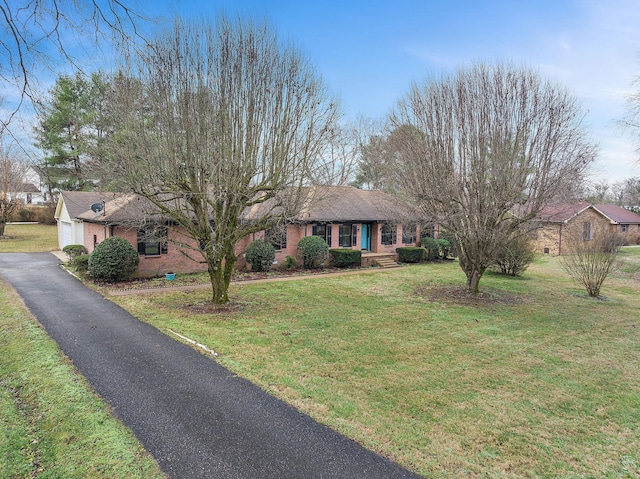 ranch-style home featuring a garage and a front yard