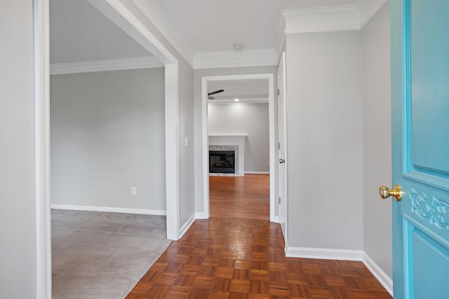 foyer entrance featuring a high end fireplace, dark parquet floors, and ornamental molding