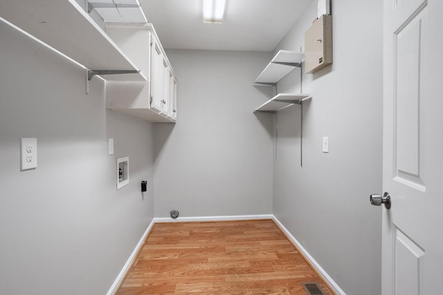 laundry room featuring cabinets, light wood-type flooring, and hookup for a washing machine