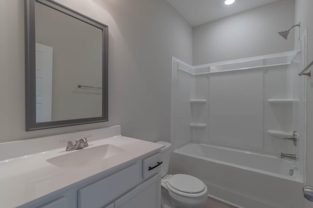 full bathroom featuring washtub / shower combination, vanity, and toilet