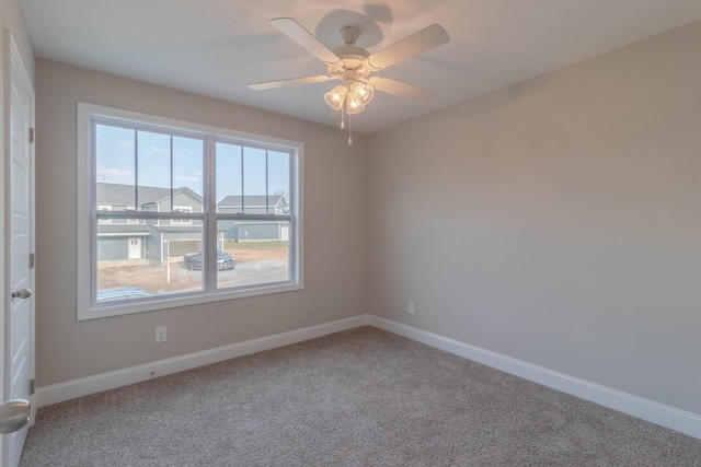 carpeted spare room with ceiling fan