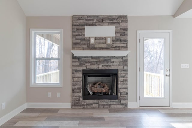 room details with hardwood / wood-style flooring and a stone fireplace