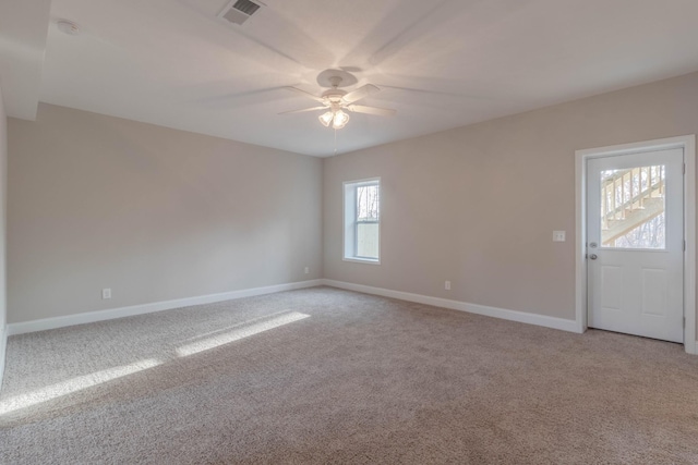 carpeted spare room featuring ceiling fan