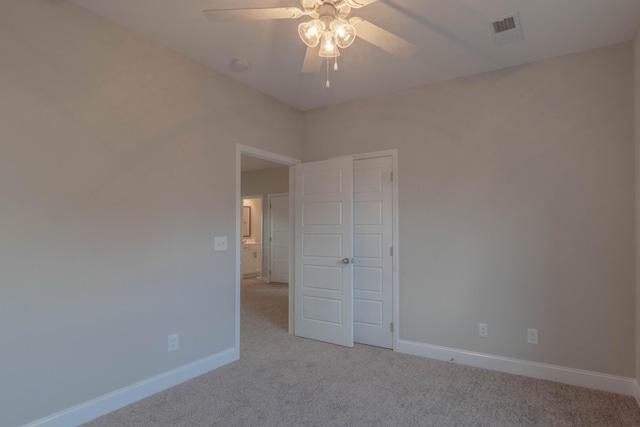 unfurnished bedroom featuring ceiling fan, light colored carpet, and a closet