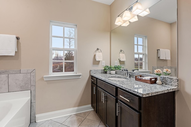 bathroom featuring tile patterned floors, plenty of natural light, a bathing tub, and vanity