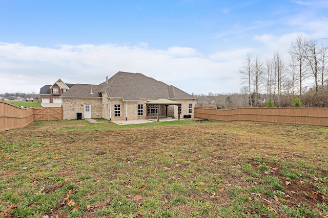 rear view of house featuring a patio area and a yard