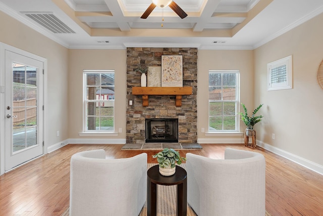 living room with a wealth of natural light, crown molding, and coffered ceiling