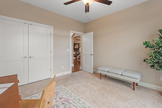 sitting room with ceiling fan and light colored carpet