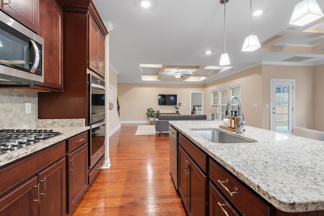 kitchen featuring beam ceiling, sink, stainless steel appliances, coffered ceiling, and a kitchen island with sink